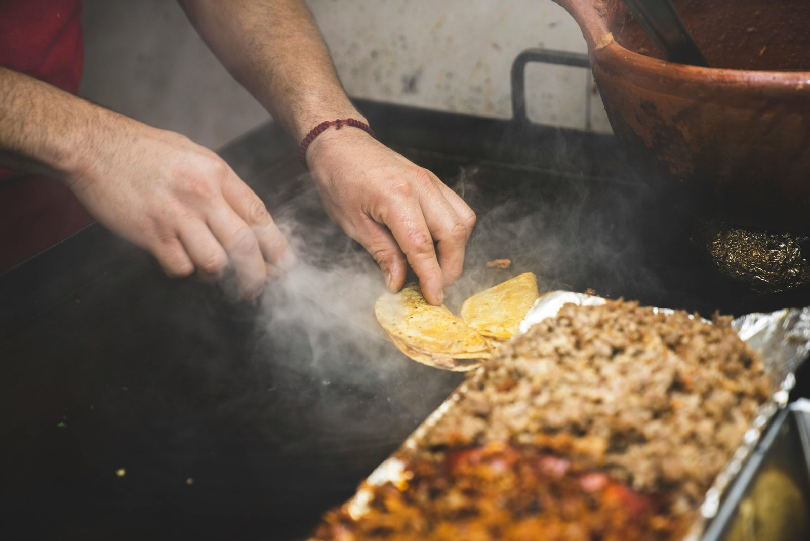 Vendor skillfully prepares authentic Mexican street tacos on a grill. Perfect for food photography.